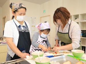 写真＝木元さん（右）からリンゴの切り方を学ぶ受講生