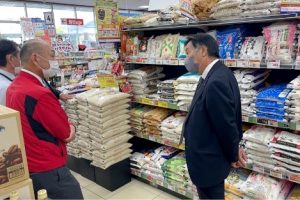 写真＝スーパーマーケットで秋田米の販売状況を確認する小原組合長（右）