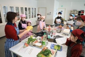 写真＝木元さん（左）から白菜の豆知識を学ぶ参加者