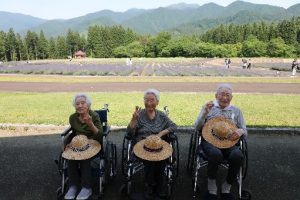 美郷町のラベンダー園をバックに記念撮影をする様子