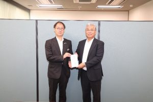 篠田常務（左）から見舞金を受け取る齊藤組合長（右）の様子