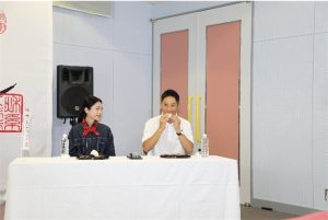 新米おにぎりをイメージキャラクターの壇蜜さんと一緒に試食しする知事の様子