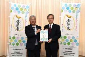 「金芽米」をデザインしたクリアファイルが松田知己美郷町長へ寄贈される様子
